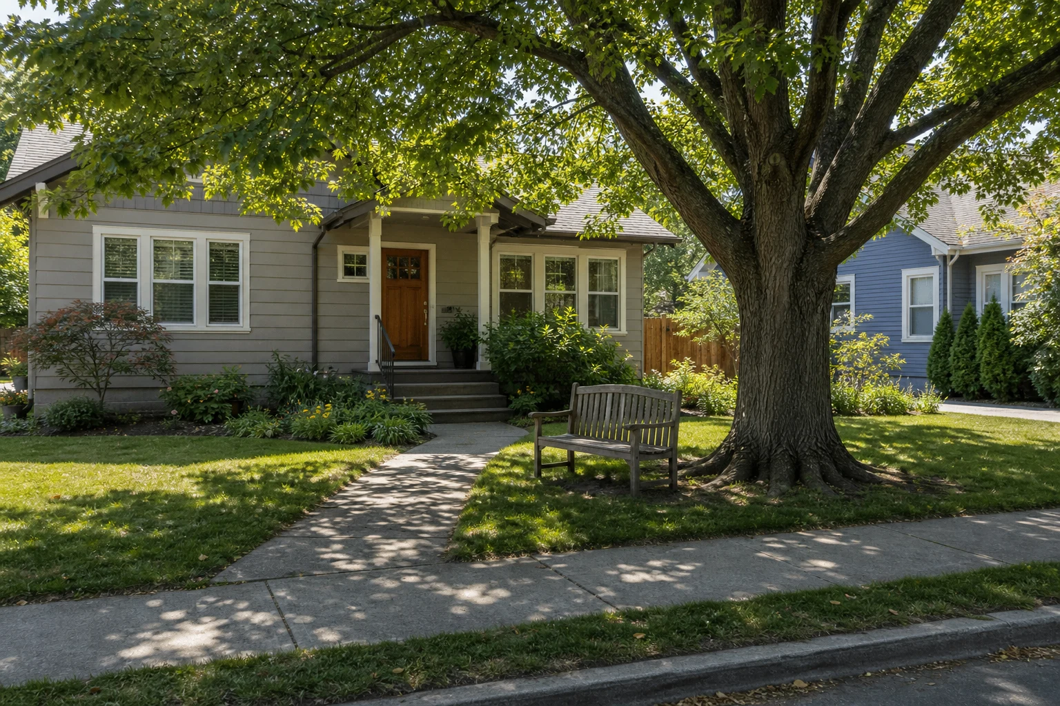 A mature front-yard tree shading a bench and part of the entry walk